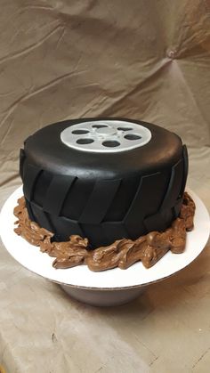 a black and white cake sitting on top of a table next to a brown cloth