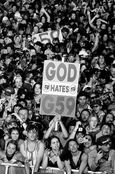 a group of people holding up signs in front of a crowd at a sporting event