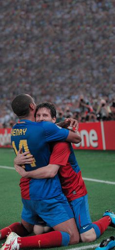 two soccer players hugging each other on the field