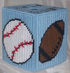 a blue knitted tissue box with baseballs and a ball on the side,