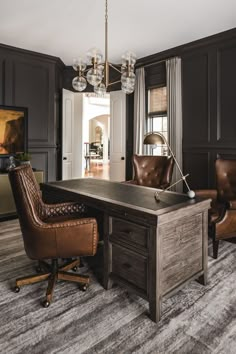 an office with two leather chairs and a desk