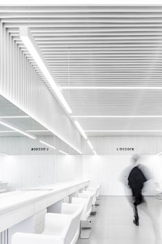 a blurry photo of a man walking through a white room