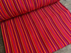 a red and blue striped fabric on a wooden floor