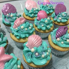 cupcakes decorated with blue and pink icing, seashells and pearls