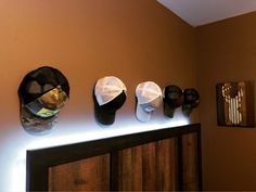 several hats are hanging on the wall above a dresser