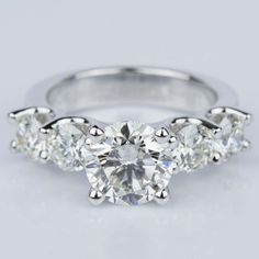 three stone diamond engagement ring in 18k white gold with diamonds on the sides and four prongs