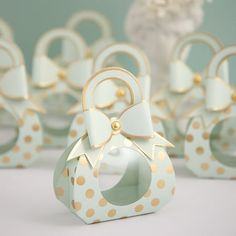 small white and gold polka dot boxes with bows on them are sitting next to each other