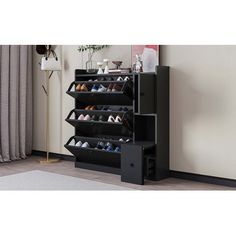 the shoe rack is black and has four pairs of shoes on it, along with a rug