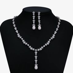 a necklace and earring set with pearls on a mannequin headdress