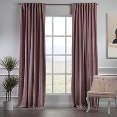 a pink chair sitting in front of a window with curtains hanging on the windowsill