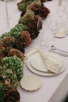 the table is set with white plates and silverware