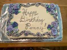 a birthday cake with frosting and purple flowers