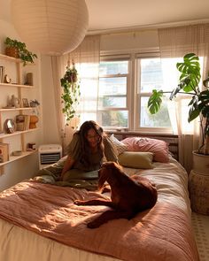 a woman sitting on a bed with her dog