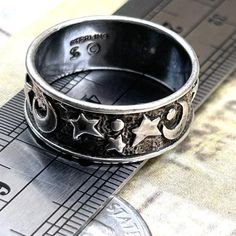 Vintage Wide Crescent Moon Stars Sterling Silver Band Ring Size 7.5 Celestial Symbols  Smoke free. Artist signed jewelry, solid sterling silver band ring, marked Sterling with dollar sign symbol mark. Has patina, darkening, age and wear. Has a weathered look.  See photos to confirm all marks. See photos for ring on sizer showing size 7.5. See ring near ruler to verify width of band. Shows wear and age. True vintage. Boho, stacking, wedding, ring, artist, designer, signed, rustic, worn, thick, band, ring, pinky ring, stacking, stackable, thumb, boho wedding band, wizard, magic theme, darkened with age, astrology, wicca, wiccan, nature, goth, jewelry. Comes in a box in secure packing with tracking. Promptly shipped. Reliable seller. Boho Wedding Band, Nature Goth, Boho Wedding Bands, Celestial Symbols, Wizard Magic, Magic Theme, Dollar Sign, Goth Jewelry, Moon Ring