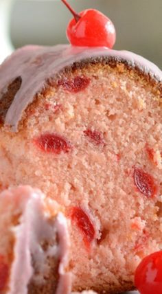 a close up of a piece of cake with cherries on top and frosting