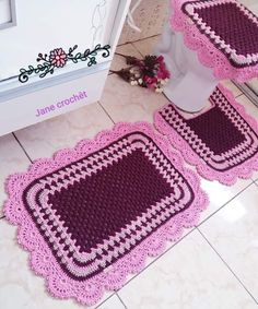 two crocheted rugs sitting on the floor next to a toilet