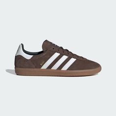 Born on the football pitch, the adidas Samba shoes are a timeless icon of street style. Inspired by a rare 1970s training shoe, this edition is marked by a deco stitch on the toecap for an altered version of the classic Samba T-toe design, as well as a revision to the eye stay and heel mustache to evolve the look of the OG Samba. A suede upper and gum rubber outsole add another nod to retro flair. Brown Adidas, Samba Shoes, Adidas Shoes Originals, Sneakers Adidas, Adidas Sneaker, Cooler Look, Cloud White