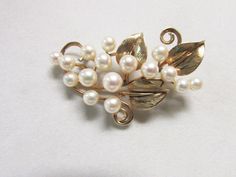 "Vintage Estate Ming's of Honolulu Mid Century 14K  16 High Luster Pearl With Leaf and Curl Gold Design Brooch Weight: 11.4 grams Brooch Size: 56.5 mm X 40.5 mm or 2 7/32\" inches X 1 19/32\" inches approx 16 Pearls: 5.5 mm -6.5 mm approx Height : 11.5 mm approx Marked: Ming's 14K Vintage Estate Ming's of Honolulu Mid Century 14K Pearl Brooch Older Ming's of Honolulu Pearl Brooch with Ming's Gold Work with Leaf and curls. Has Ming's Distinctive Gold Design Mings used in Their Jewelry Piece. 16 H Heirloom Style White Brooch For Formal Occasions, Heirloom White Brooch For Formal Occasions, Heirloom White Brooches For Formal Occasions, Gold Wedding Jewelry Necklace, Purple Jade, Gold Wedding Jewelry, Gold Work, Jade Ring, Pearl Brooch