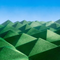 the green hills are covered with grass under a blue sky