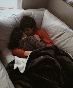 a man and woman cuddle together on a couch