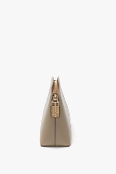 This textured, semi-shine, calf leather crossbody bag is a new silhouette in the Victoria Beckham leather goods edit. Presented in understated Taupe, it has a structured design with an elegant curved top that marries masculine and feminine references beautifully. A favourite of Victoria’s, it has an adjustable and removable strap for versatile styling, engraved zip puller with padlock closure and internal flat pocket for secure storage. Leather panels stitched to form the house’s signature V sha Classic Crossbody Business Clutch, Classic Crossbody Clutch For Business, Classic Business Crossbody Clutch, Everyday Luxury Crossbody Bag With Smooth Grain, Sleek Leather Clutch For Business, Modern Luxury Clutch With Removable Pouch, Modern Leather Clutch With Smooth Grain, Evening Crossbody Bag With Smooth Grain, Timeless Leather Clutch For Business