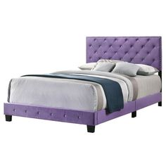 a bed with purple upholstered headboard and pillows