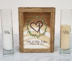 a couple of glasses sitting on top of a table next to a box with the initials mr and mrs