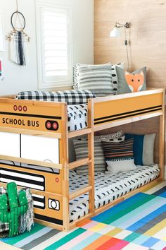 a school bus bunk bed in a child's room with colorful rugs and pillows