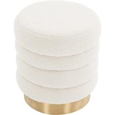 a stack of white round cushions sitting on top of a gold base