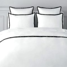 a white bed with blue trim and pillows