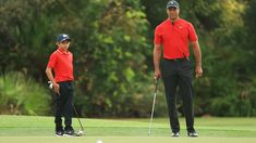 two men standing next to each other on a golf course