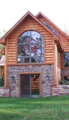 a log home with large windows in the front and side of it's building