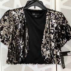 Wedding Guest Formal Jacket With Sequins. Short Sleeves. Size: Medium. New With Tag. Metallic Sequined Outerwear For Formal Occasions, Metallic Sequined Outerwear For Formal Events, Elegant Metallic Outerwear With Sequins, Silver Sequined Outerwear For Evening, Elegant Metallic Sequined Outerwear, Silver Sequined Evening Outerwear, Silver Party Outerwear, Fitted Silver Sequined Outerwear, Fall Wedding Outerwear With Sequins