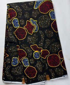 an image of a black and yellow cloth with red, blue and yellow designs on it