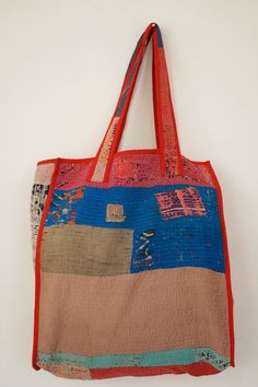 an orange and blue tote bag hanging on a wall