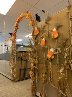 an office decorated for halloween with pumpkins and corn stalks on the wall next to it