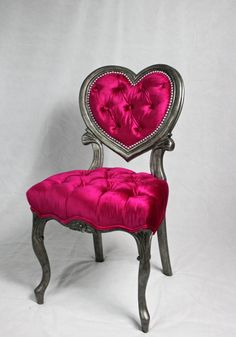 a pink chair with a heart shaped back rest