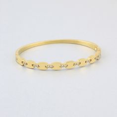 Add subtle sophistication to your bracelet stack with the Athena embellished bangle. Part of our Stackable Tennis Jewelry assortment. Hinged bangle bracelet, pavé cubic zirconia. 7" diameter. Gold: 18K gold plated steel. Silver: stainless steel. Avoid water, soap, and harsh chemicals. Store in a box or bag in a cool, dry place. Clean using a dry soft cloth. Classic Gold-tone Bangle Bracelet, Stackable Yellow Gold-plated Bangle, Adjustable Stackable Gold-plated Bangle, Luxury Stackable Gold-plated Bracelet, Gold-toned Brass Bangle Bracelet, Tennis Jewelry, Hinged Bangle, Bracelet Stack, Silver Bracelets