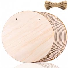 four unfinished wooden discs are stacked on top of each other with a tassel attached to the disc