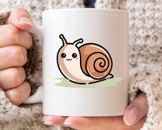 a woman holding a coffee mug with a snail on it