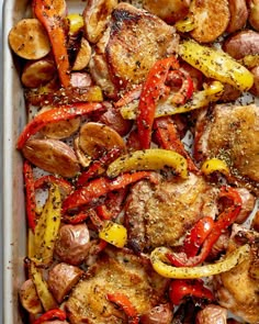 chicken, peppers and potatoes in a baking dish with seasonings on top for garnishes