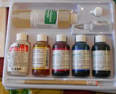 the contents of an artist's paint set in a plastic container with brush and ink