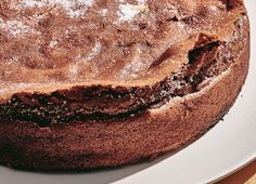 a chocolate cake is sitting on a white plate