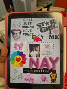 a person holding up an electronic device with stickers and pictures on the front cover