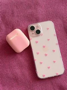 an iphone case with hearts on it next to a pink apple airpods plugged in