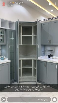 a kitchen with grey cabinets and white counter tops in arabic writing on the bottom right corner