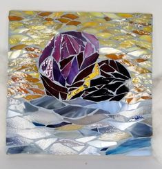 a piece of art that is made out of different colored pieces of glass and silver foil