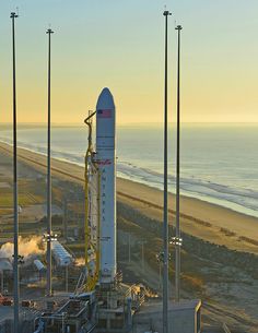 a rocket is sitting on top of a building near the beach