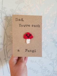 a hand holding up a card with a red flower on it that says, dad you're such a funi