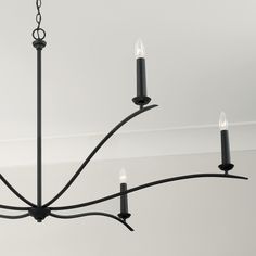 a black chandelier with five candles hanging from it